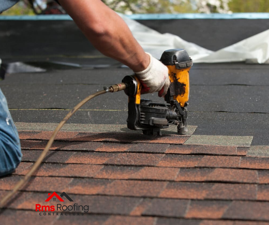 Contractor fixing flashing on a roof to prevent leaks during a roofing installation project.